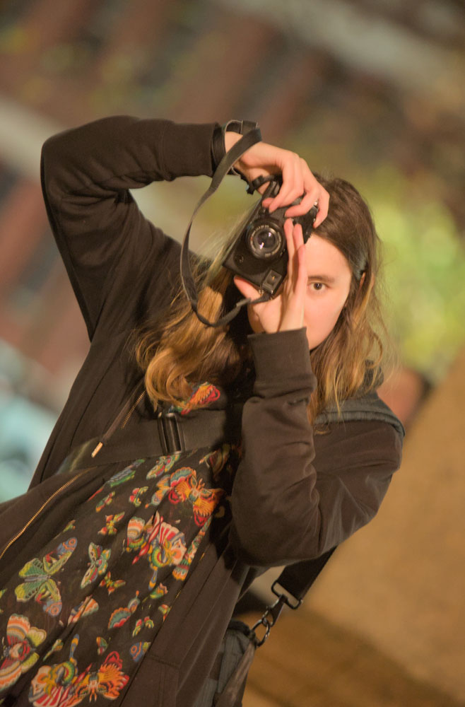 A photo of my partner in the act of taking a photo of me, taken at 200mm.
